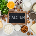 Calcium rich foods including milk cheese yoghurt almonds spinach beans and nuts arranged around a chalk blackboard